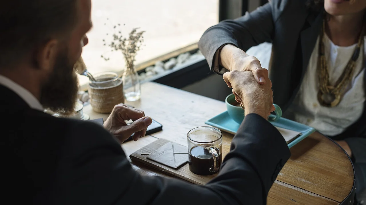 Dubai dual licence agreement: two business people shaking hands over a table
