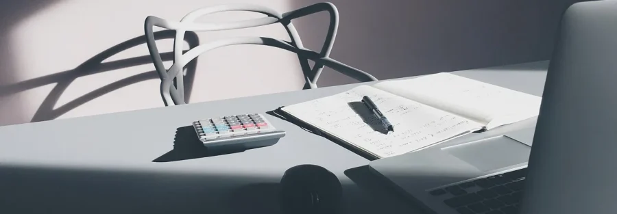 Calculator, notebook and laptop on a desk used for Dubai property valuation