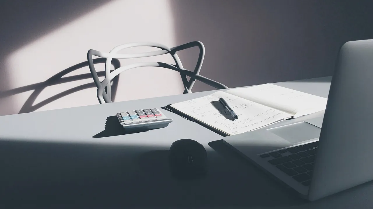 Calculator, notebook and laptop on a desk used for Dubai property valuation