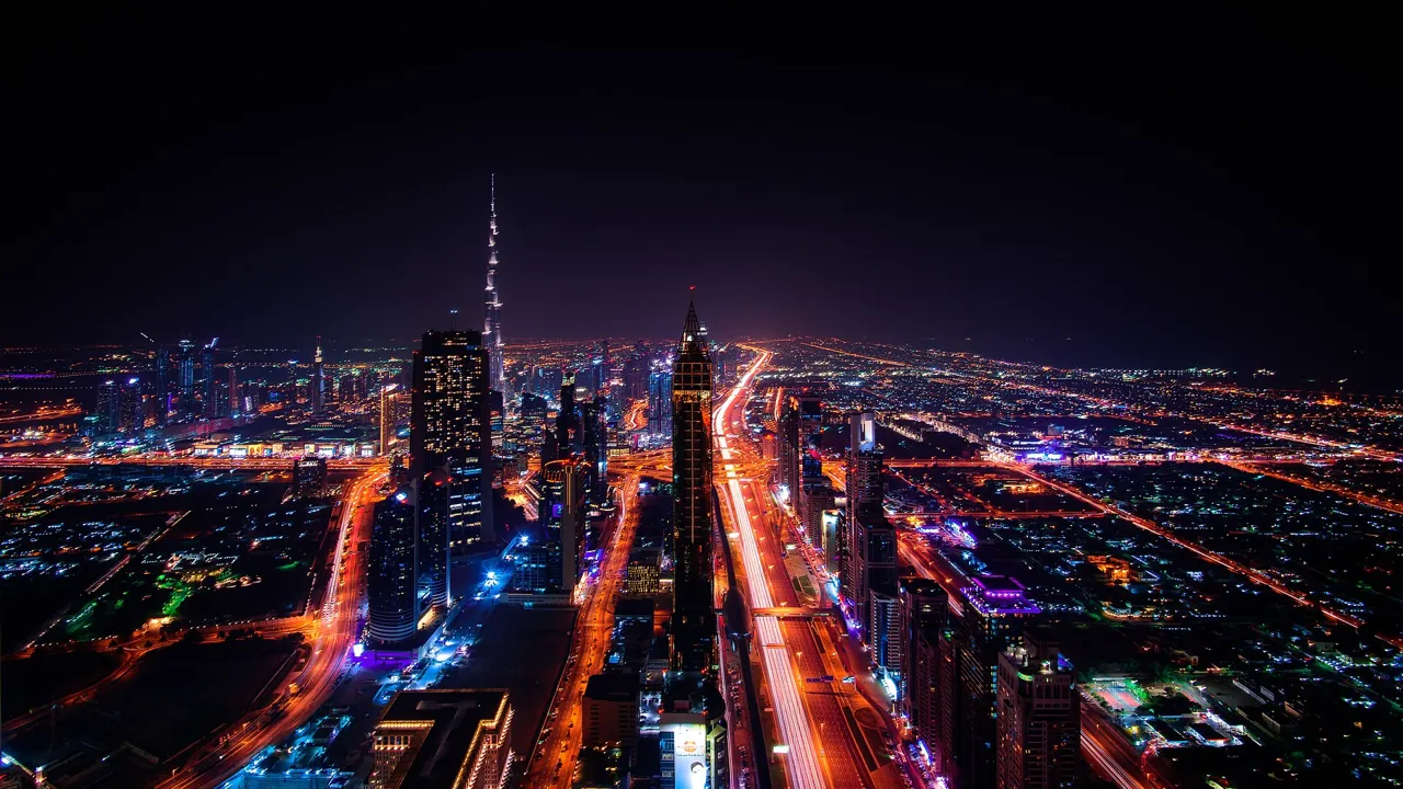 Dubai REITs and property investment: aerial night view of Sheikh Zayed Road and the Dubai skyline
