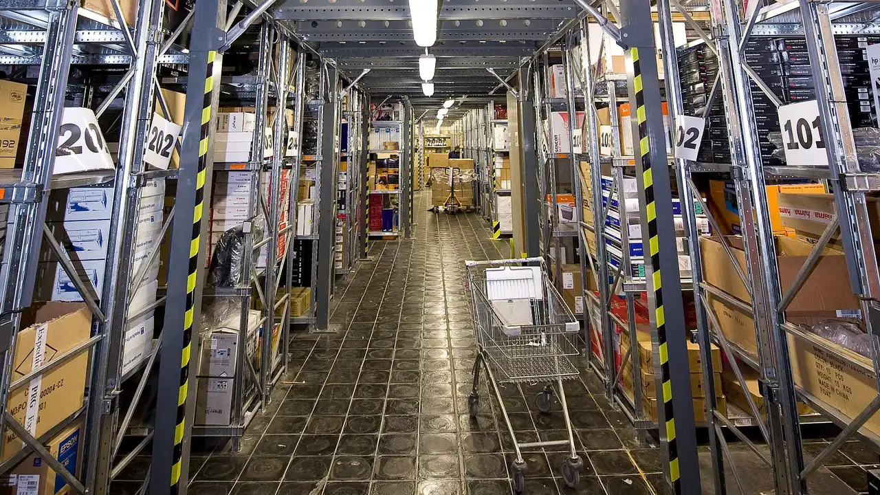 A warehouse aisle with stock shelves: storage space is part of choosing an e-commerce licence UAE route