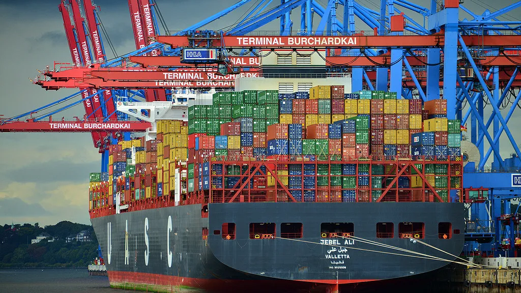 Container ship Jebel Ali loading at a terminal, an example of importing goods into Dubai by sea