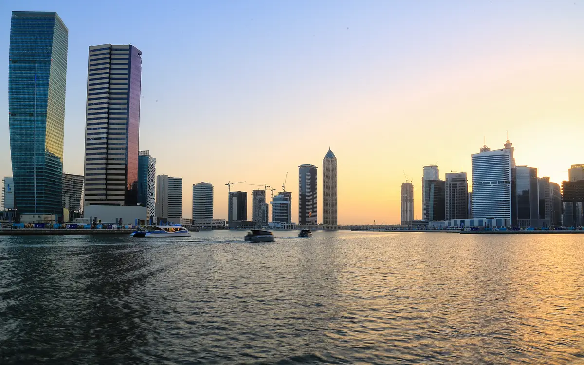 Business Bay towers over the Dubai Water Canal at sunset, a typical setting when owners sell a UAE company