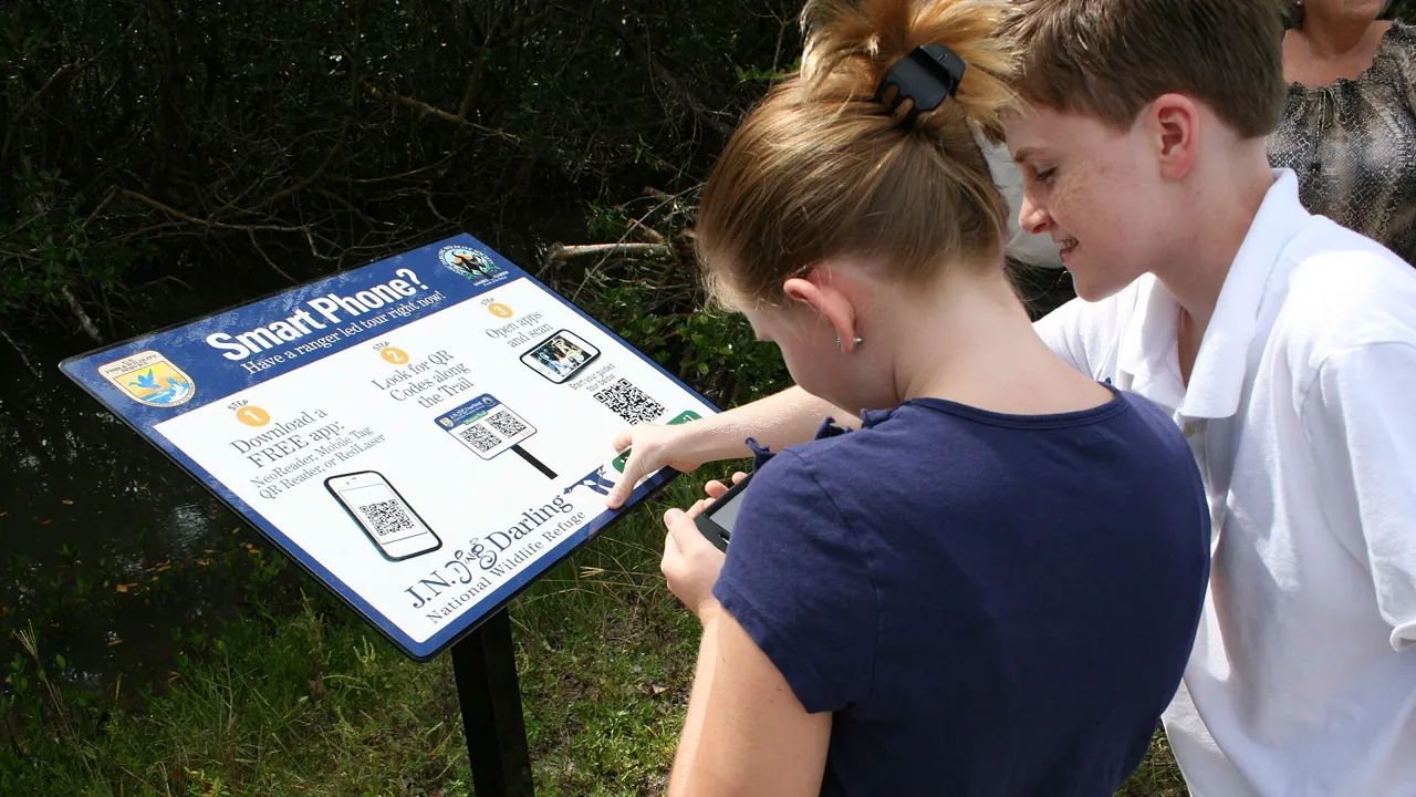 Trakheesi permit check: scanning a QR code on a sign with a smartphone