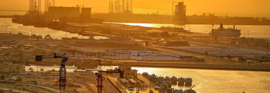 Port Rashid in Dubai at sunset: cranes, ships and cargo yards that show why the UAE commercial agency law matters to importers