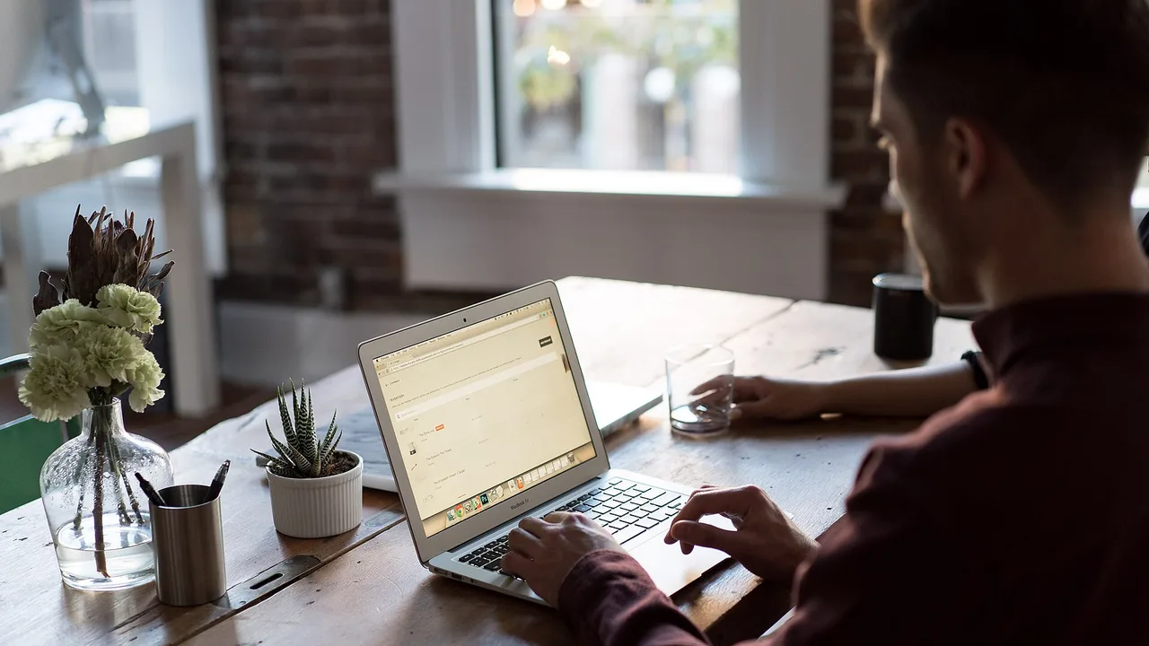 Man working on a laptop at a wooden desk to file UAE corporate tax deregistration online