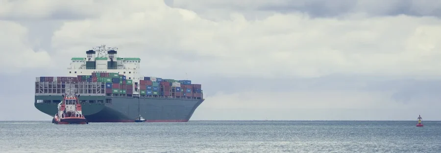 UAE zero-rated vs exempt supplies: a container ship loaded for export leaving port with a tug alongside