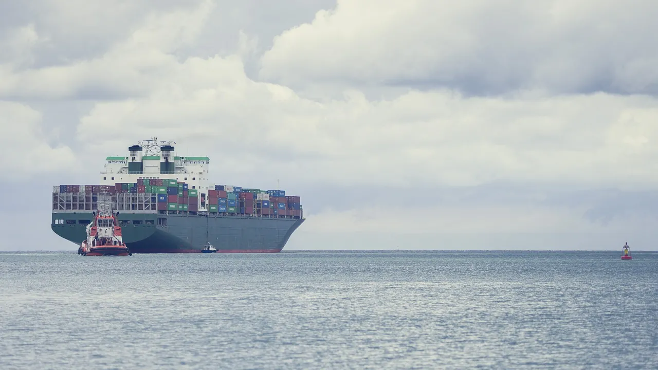 UAE zero-rated vs exempt supplies: a container ship loaded for export leaving port with a tug alongside